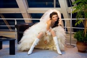 Attractive bride with knee boots on showing legs